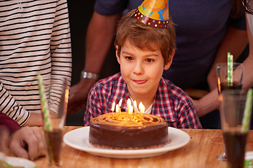 Image showing Excited, child and candles on birthday cake at party in celebration and hungry for food on table. Happy, kid and family together at event to relax and enjoy growth development of boy in home