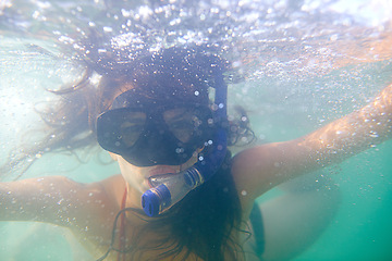 Image showing Woman, snorkeling and swimming on holiday in water, sport and diving for travel, fun and activity. Scuba, diver and mask in underwater, sports and adventure with equipment, pool or reef on vacation