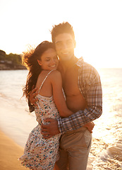 Image showing Love, embrace and happy couple at ocean sunset for tropical holiday adventure, relax and bonding together. Nature, man and woman smile on romantic date with beach, sky and hug on island vacation.