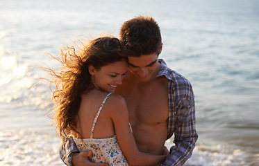 Image showing Sunshine, couple hug on beach and ocean, travel for anniversary or date with bonding, love and support. Affection, peace and fresh air in nature, people outdoor with trust and care in relationship