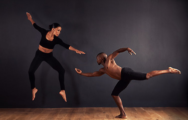 Image showing Dancers, dramatic and performance in studio with dark background, male and female ballerina being creative together. Athletics, competitive and sports for fitness, diverse people, art and movement.