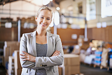 Image showing Woman, smile and crossed arms for portrait in warehouse for logistics, shipping or distribution. Business person, happy and confident in factory with production for supply chain industry in Liverpool