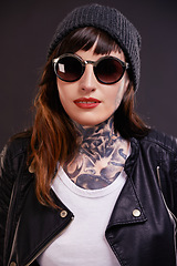 Image showing Confident, woman and punk fashion in studio for trendy rocker style with sunglasses. Bold, female person and leather clothes for creative skin tattoo, art decoration and grunge by dark background