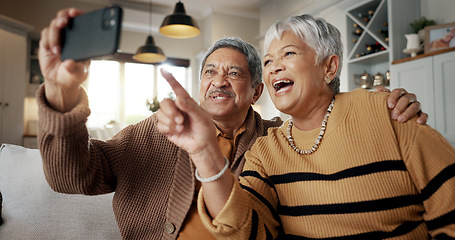 Image showing Senior couple, selfie and happy on sofa, hug or talking for choice, check post and point for photography in home. Elderly woman, man and laugh with profile profile, web blog and social media on couch