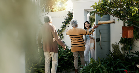 Image showing Happy family, open door and hug with flowers outdoor of home in backyard with daughter and parents with love. Reunion, welcome and woman with mom and dad, travel and surprise for holiday with embrace