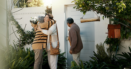 Image showing Happy family, open door and hug with flowers outdoor of home in backyard with daughter and parents with love. Reunion, welcome and woman with mom and dad, travel and surprise for holiday with embrace