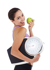 Image showing Portrait, scale and woman with fitness, apple and healthy person isolated on a white studio background. Face, happy girl and model with wellness and exercise with diet plan and weight loss with goals