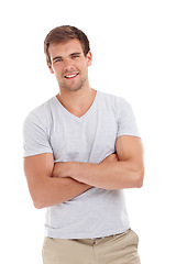 Image showing Man, portrait and happy or arms crossed in studio with casual fashion, confidence and trendy outfit with pride. Model, cool person and smile with relax, good mood and tshirt on white background