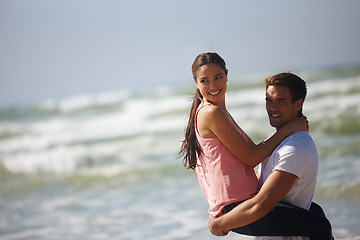 Image showing Sea, couple and man lifting woman, travel and freedom at beach for bonding and anniversary date in nature. Happy, partner and commitment with view, affection and playful outdoor for love and fun