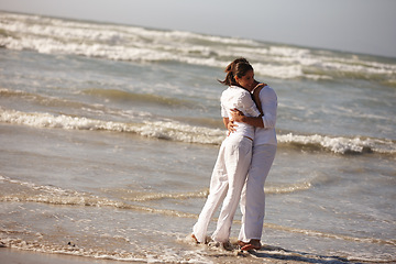 Image showing Couple, hug and embrace on beach for love, support or valentines day in outdoor nature. Man and woman enjoying holiday, weekend or getaway together for bonding or romance by the ocean coast or sea