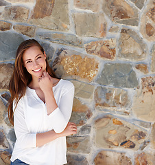 Image showing Woman, portrait and smile by stone wall in home with confidence, relax or casual outfit on mockup space. Person, face and happy for holiday, vacation or peaceful getaway with shirt, good mood or calm