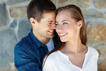 Image showing Outdoors, couple and embrace for love, touch and romance or care on wall background. Happy people, relaxing and smile for pride in relationship or commitment, loyalty and connection on holiday