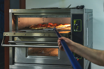 Image showing Chef monitors a pizza