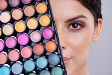 Image showing Eyeshadow, makeup palette and portrait of woman in studio for cosmetics, powder and foundation on gray background. Closeup, beauty and female model with cosmetology product, facial glow and skincare