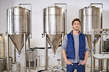 Image showing Beer, production and man in portrait and factory or distillery for winery, alcohol and drink manufacturing. Worker or winemaker working by tank, metal or steel pipe of fermentation vessel in brewery