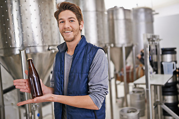 Image showing Brewery, man and bottle with portrait in factory with confidence, craft beer or tank machine for manufacturing. Industrial, worker or smile in career with production line for brewing in warehouse