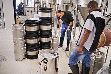 Image showing Men, brewery equipment and craft beer with pipe at factory with production process at small business. People, fermentation and manufacturing with container, tools and team with alcohol in workshop