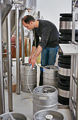 Image showing Brewery, man and pipe in tank with manufacturing for craft beer, alcohol and production process in factory. Industrial lager, worker and working with drum equipment for brewing in warehouse system