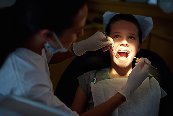 Image showing Dental, mirror or girl with dentist for mouth exam, tooth cavity or gum disease, bacteria or search. Oral care, wellness or doctor with light, equipment or tool for pediatric dentistry or cleaning