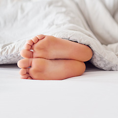 Image showing Feet, person and soles in bed with blanket for sleeping, comfort and warmth in the morning. Foot, toes and heels with duvet cover in bedroom on mattress for relax, tired and cozy in house on weekend