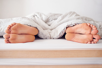 Image showing Feet, couple and relax in bed of home, sleep and peace in morning on holiday or weekend. Love, partnership or married people, barefoot and blanket or duvet for bonding and rest on vacation in bedroom