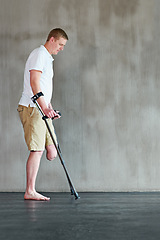 Image showing Physical therapy, patient with disability or amputee walking with crutches at clinic for recovery, strength and healthcare rehabilitation. Physiotherapy, support and consultation or workout for man