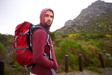 Image showing Man, hiking and mountain and portrait in nature, Germany trail on wildlife conservation. Active, male person on adventure for health and wellness, confident explorer on rocky terrain for sport