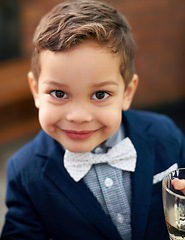 Image showing Young, child and portrait with bowtie, suit and smile for fashion, style and classic in outdoor. Cute, boy and outfit as gentleman, growth and development in childhood, fun and playful for event