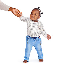 Image showing Baby, parent and help walking in studio for fashion, jeans or clothing or development. Girl, isolated on backdrop or standing support with person for trend, holding hands or smile or kid in Brazil