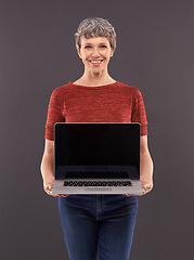 Image showing Elderly, woman and laptop screen in studio with smile, technology and online search or typing and internet connection. Information, browse or social network, senior female person on mockup background