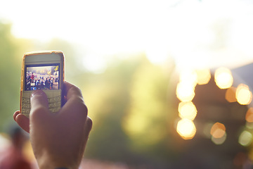 Image showing Hand, phone and picture at festival, blurry background and button for photography at concert. Mobile, online and internet with connection, technology and crowd for entertainmen in event outdoor