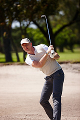 Image showing Man, golfer and hit with club on golf course in sand pit for stroke, point or strike by grass field in nature. Male person or sports player with swing on ball in dirt for par, game or outdoor match