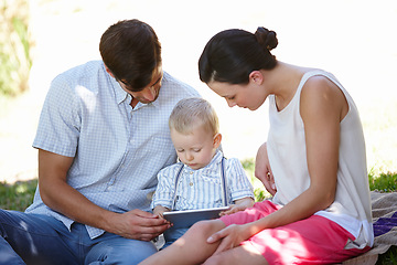 Image showing Parents, child and tablet for growth, development and education with e learning in garden. Man, woman and boy on technology, educational gaming and online for motor skills, bonding and togetherness