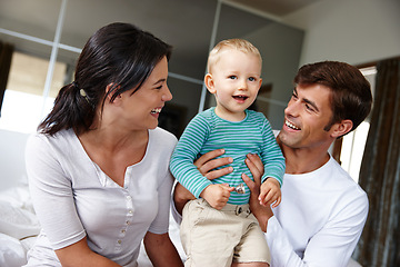 Image showing Family, happiness and parents with child in the home, love and security with parenting, childhood and bonding. Support, trust and care with man, woman and young boy in bedroom, smile and positivity