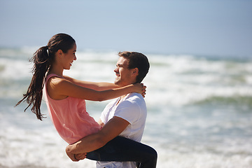 Image showing Ocean, couple and man lifting woman, travel and freedom at beach for bonding and anniversary date in nature. Happy, partner and commitment with hug, affection and playful outdoor for love and fun