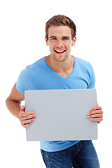 Image showing Man, portrait and board in studio with poster for advertising space, presentation or promotion sign. Model, smile and cardboard for banner, announcement and mockup for information on white background