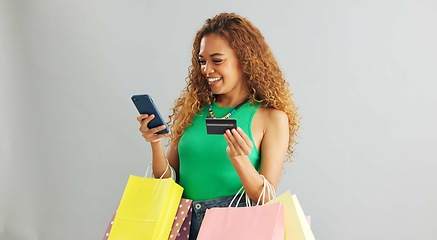 Image showing Happy woman, phone and credit card with shopping bags for payment on a gray studio background. Female person with smile or debit on mobile smartphone for online purchase, banking or app on mockup