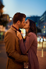 Image showing Couple, night and city with kiss on date, romance and bonding with love in relationship. Happiness, affection and people with commitment and trust, sweet moment and romantic together outdoor