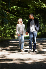 Image showing Couple, hand holding and happy walking in park for love, bonding with care and support in healthy relationship. Man, woman and outdoor for date with romance, trust and commitment for marriage