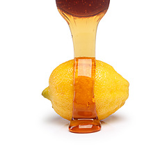 Image showing Organic, lemon and honey poured in studio to remedy as natural, medicine and treatment for flu. Healthy, cure and immune boost drink for healing virus, disease and influenza on white background