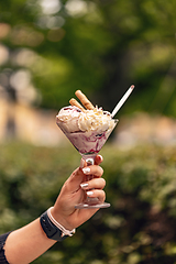 Image showing Woman is holding a glass cup of ice cream