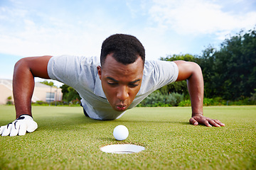 Image showing Desperate golfer and cheating, blow ball in hole for victory on green field at competition. Serious man and closeup for challenge, sports fraud on target outdoors on grass or lawn at country club