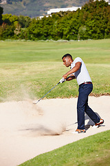 Image showing Man, swing and club on golf course in sand pit for par, bogey or stroke with grass field in nature. Young male person, golfer or sports player hitting ball out for strike, point or tough outdoor shot