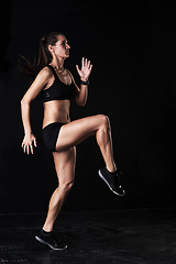 Image showing Fitness, gym and woman athlete in studio running for competition, race or marathon training. Sports, workout and female runner with cardio exercise for health or wellness by dark black background.