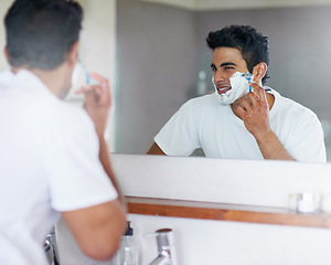 Image showing Foam, mirror and man with razor in bathroom for hygiene, grooming and washing face at home, house and apartment. Male person, gen z guy and reflection of student with shaving cream, face or skin care