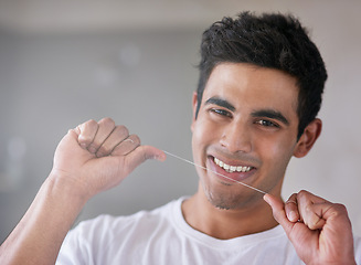 Image showing Happy, portrait and man with floss in bathroom for dental hygiene, gum disease and oral care. Health, mouth and person with smile after brushing teeth for wellness, cleaning and fresh breath in home