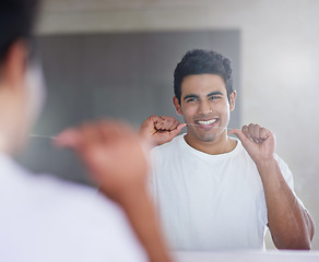 Image showing Smile, mirror and man with floss in bathroom for dental hygiene, gum disease and oral care. Health, happy and person in reflection after brushing teeth for wellness, cleaning and fresh breath in home