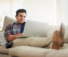 Image showing Man, laptop and home for internet connection with streaming service for free time, stress relief or resting. Male person, smile and couch with technology for online subscription, watching or blogging