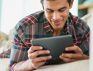 Image showing Man, tablet and reading ebook on sofa for relax weekend in apartment with subscription, entertainment or connection. Male person, technology and browsing service for holiday day off, blog or online