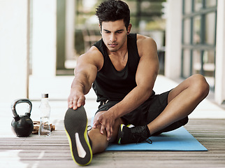 Image showing Man, stretching and exercise for legs in home and start with healthy preparation for workout. Training, flexibility and athlete warm up body with yoga for fitness, challenge and prevent sports injury